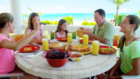 caucasian family dining on vacation beach hotel decking