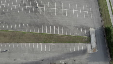 Abandoned-parking-lot,-run-down-building,-aerial,-drone