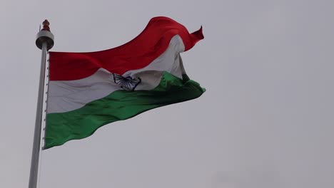 indian national waving flag with bright cloudy sky from unique angle