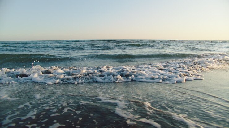 Onde dell'oceano su una spiaggia all'alba o al tramonto