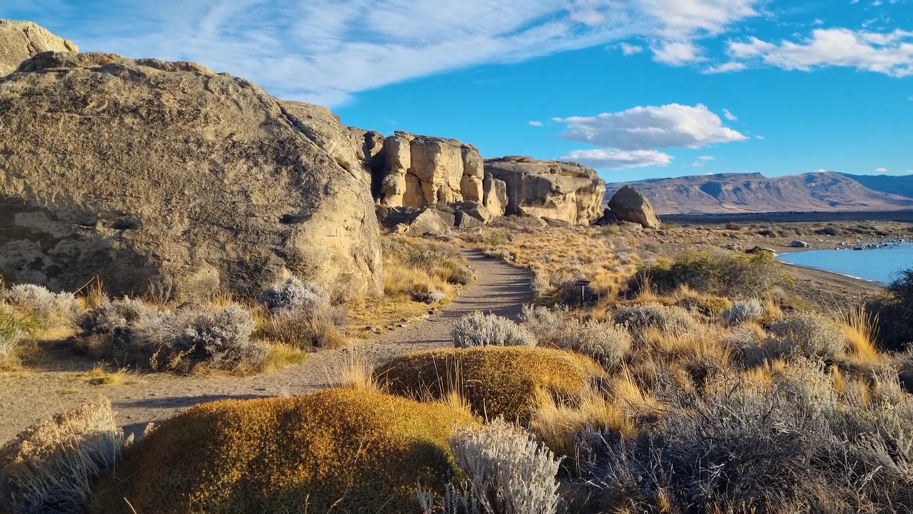 Varmt kveldsolskinn bader det arkeologiske funnstedet Punta Walichu nær El Calafate, Argentina, hvor barske patagonske landskap møter det turkise vannet i Lago Argentino.