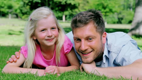 Father-and-daughter-smiling-as-they-look-at-each-other-before-looking-at-the-camera