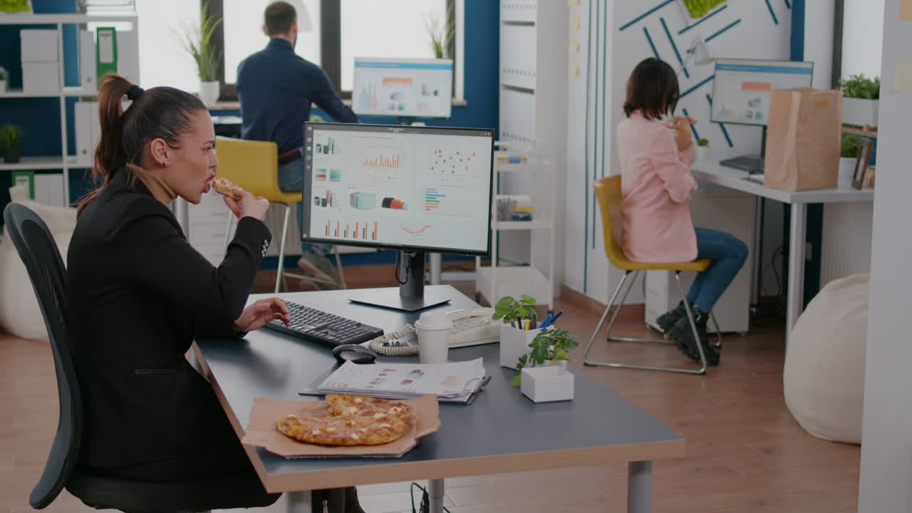 mujer de negocios en la pausa para el almuerzo en su mesa comiendo pizza entrega de comida rápida