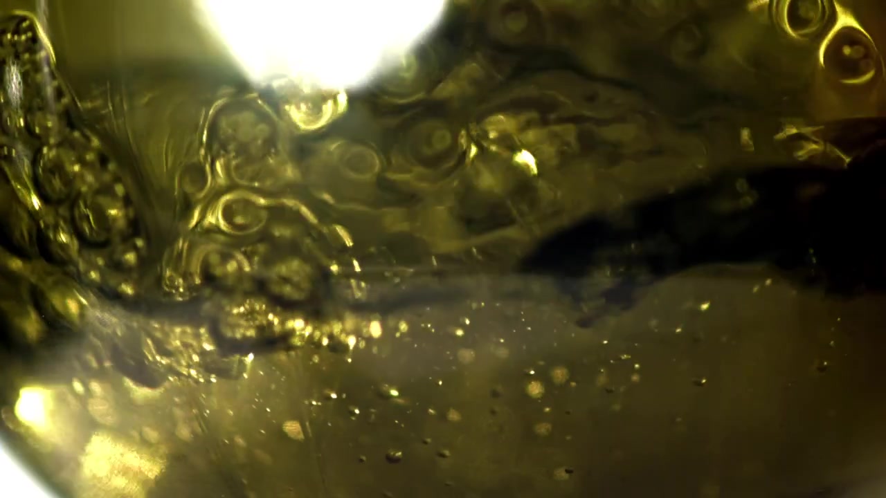 Liquido dorato con bolle e movimento vorticoso