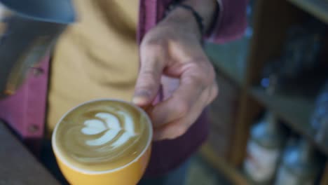 barista vertiendo leche en una taza de café