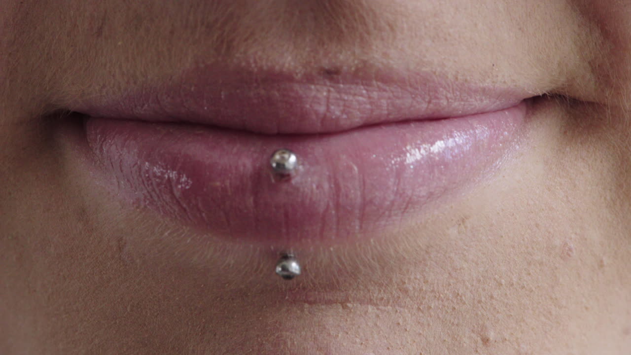 da vicino labbra di donna sorridente felice indossando piercing trucco cosmetici bellezza femminile
