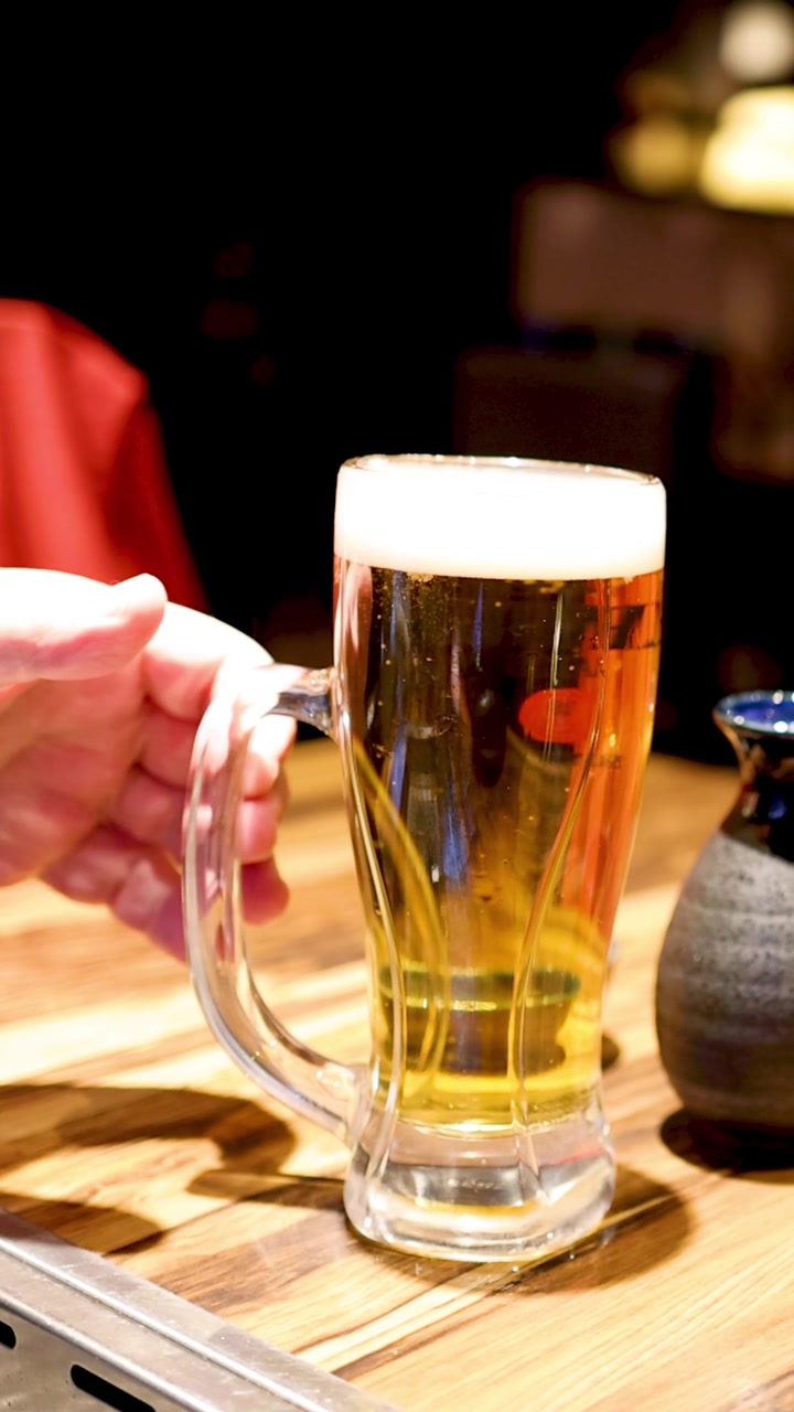 Due persone che si scambiano un bicchiere di birra