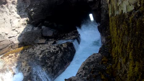 ocean splashing on its way out of a cave at a small beach in pucusana town, a fishing cove located in perú