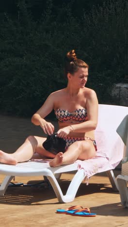 people sitting by the poolside of a resort swimming pool during summer holiday
