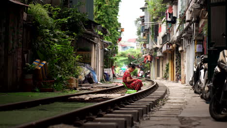 woman sitting on train tracks in hanoi's old town