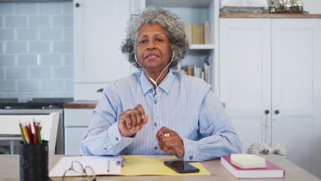 portrait of senior african american female doctor talking while having a video call at home