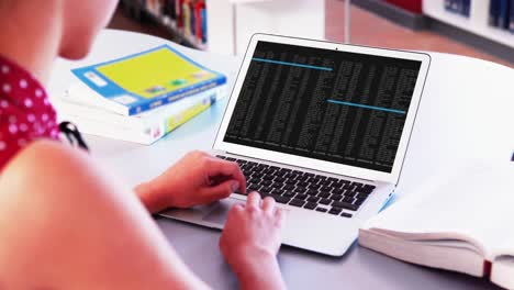 mujer caucásica sentada en un escritorio codificando datos en una computadora portátil