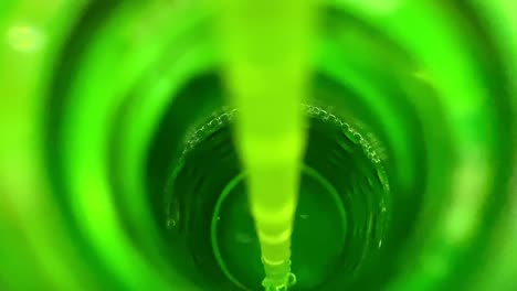 macro shot of straw in green bottle with bubbles fizzing