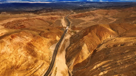 bare mountains split by the highway. drone footage above the deserted rocky landscape in nevada, usa. top view.