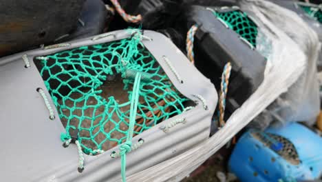 close up fishing harbour group of stacked lobster pot netting cage on coastal marine waterfront dolly right