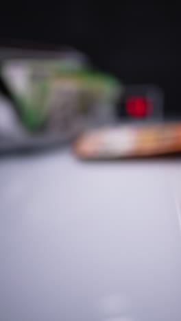 blurred image of bank device counting money. a hand takes cash from a currency counting machine. banknotes placed on the desk slide to the foreground. close up. vertical video.