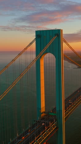 wonderful construction of whitestone bridge in new york. huge massive bridge in the lights of setting sun. vertical video