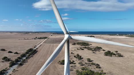 tracking drone shot of spinning wind turbine