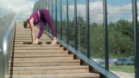 woman practicing yoga on outdoor stairs