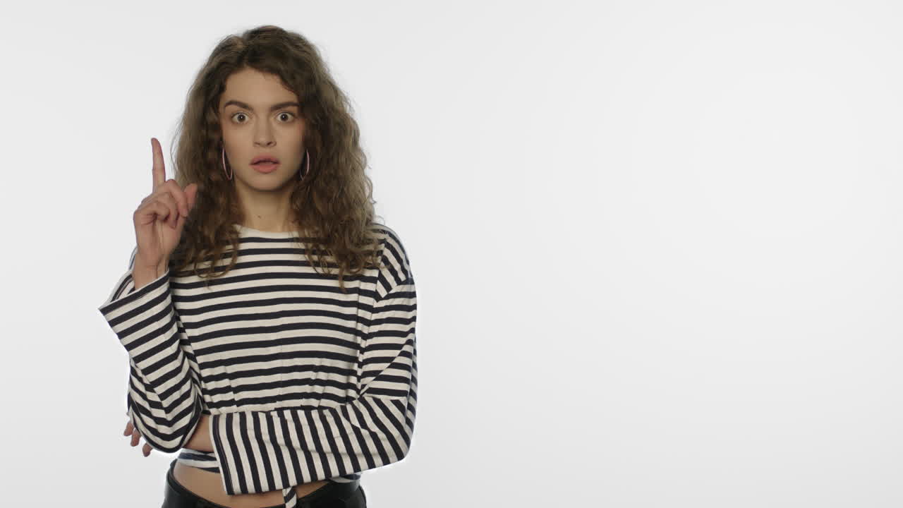 una mujer emocionada tiene una idea sobre un fondo blanco. una estudiante tiene una buena idea