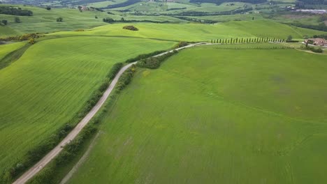 Imágenes-Aéreas-Tomadas-En-El-Campo-De-La-Toscana-Que-Muestran-Un-Camino-De-Piedra-Que-Conduce-A-Una-Propiedad-Toscana-Tradicional