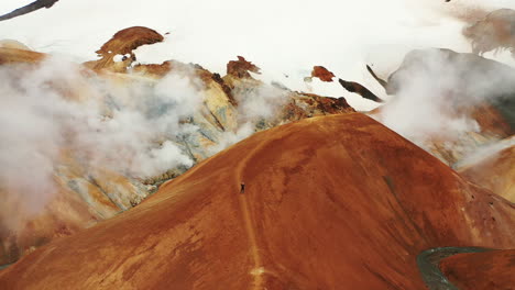 Person-Standing-On-The-Trail-In-Hveradallir-Geothermal-Area-In-Kerlingarfjoll-Mountain-Range-In-Highlands-Of-Iceland---orbiting-drone-shot