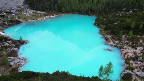 Aerial-panoramic-shot-of-turquoise-waters-of-Lake-Sorapiss,-tourists-around