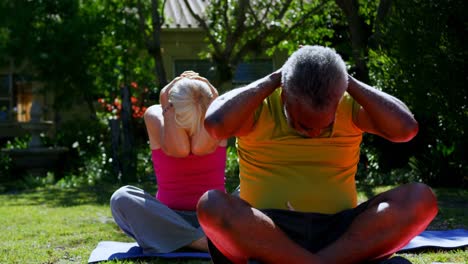 Front-view-of-active-mixed-race-senior-people-performing-yoga-in-the-garden-of-nursing-home-4k