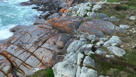 fly over the colourful rocks that form part of the bay of fires in north east tasmania