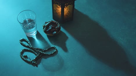 High-Angle-Shot-of-Dates-Water-Beads-and-Lantern-On-a-Table