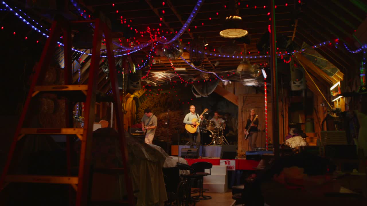 la cámara sube a un escenario mientras toca una banda