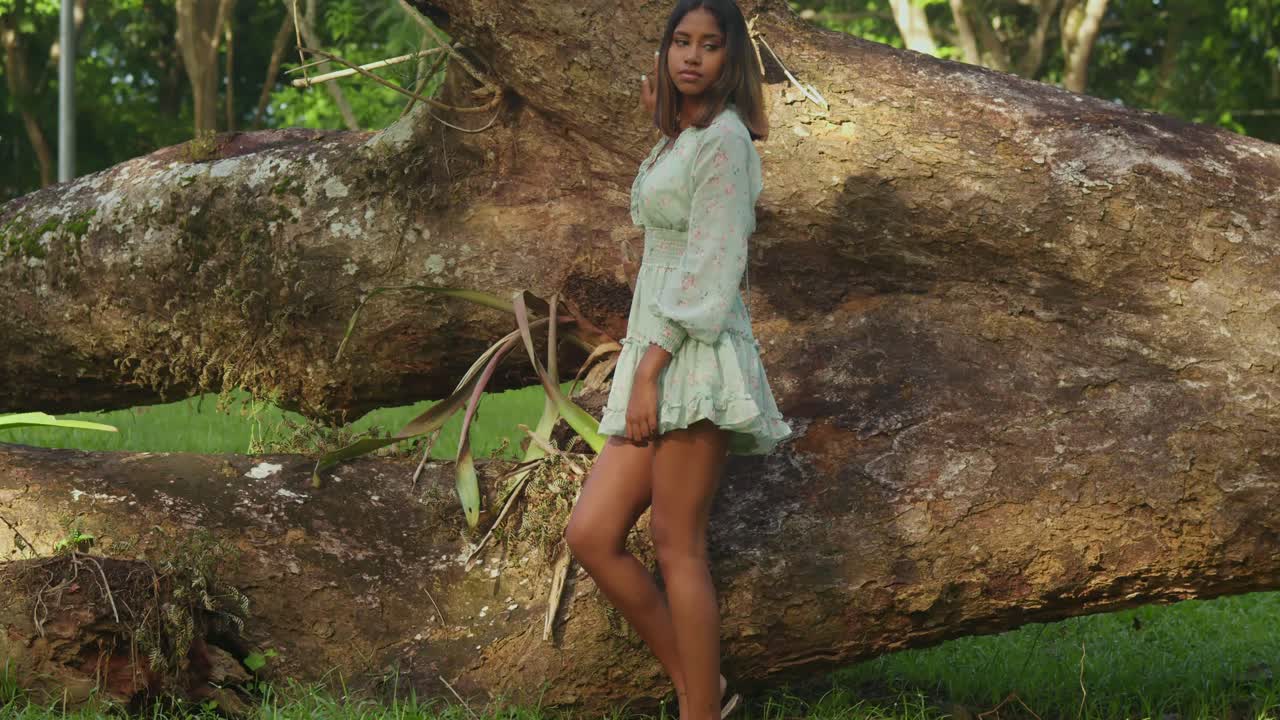 en un día soleado, una joven de cabello rizado se divierte en un parque tropical.