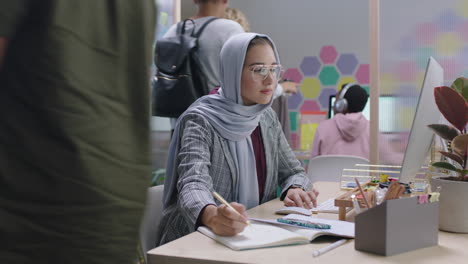 young muslim business woman using computer brainstorming browsing online research ideas for startup company project networking reading email in busy modern office workplace