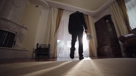 groom with wedding bouquet in his hands at home. white shirt, jacket