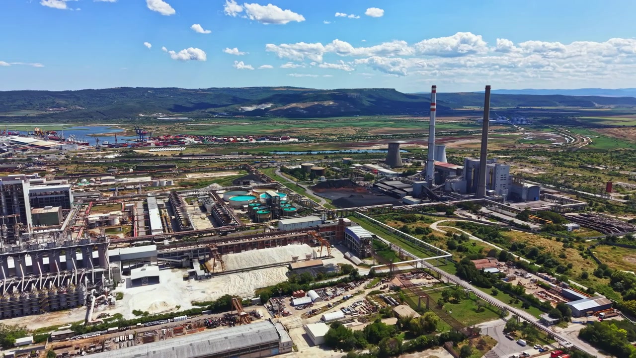 Vista di una vasta area industriale con edifici, fabbriche e montagne sullo sfondo durante il giorno