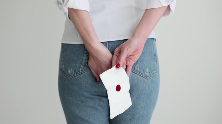 Person holding a blood-stained tissue behind their back
