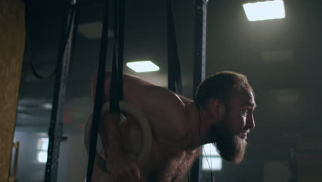 fitness-bodybuilding-and-people-concept-young-man-doing-push-ups-on-gymnastic-rings-in-gym.-Handsome-young-sportsman-with-artificial-leg-doing-push-ups-with-hanging-rings-of-gymnastics-ladder-at-gym