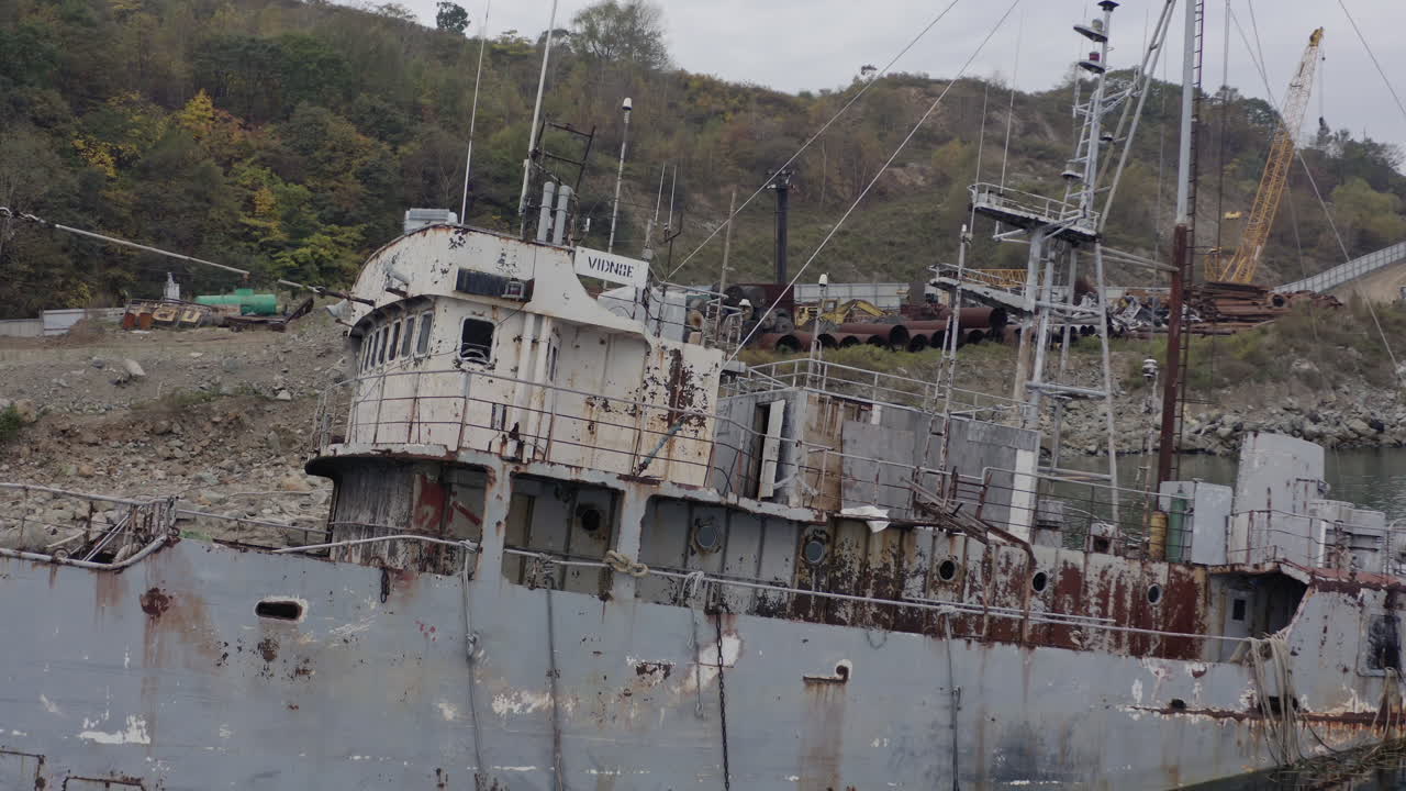 흐린 흐린 날 해안 근처에 정박한 녹슨 회색 반 침수 난파선