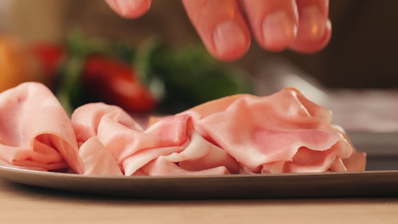 Ham italian mordatella, man Slices Of Traditional Italian antipasti mortadella sausage on a wooden cutting board, close up macro of chicken or turkey jamon, fat breakfast dish.