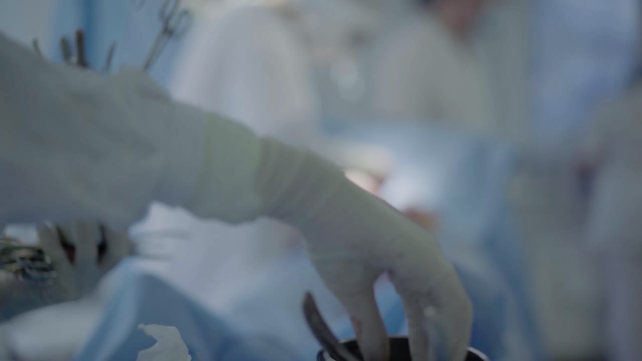 Nurse takes sterilized instruments for surgery on the heart by surgeons
