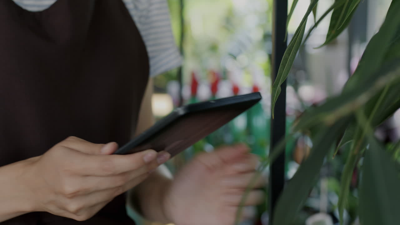 Donna che usa un tablet in un negozio di piante