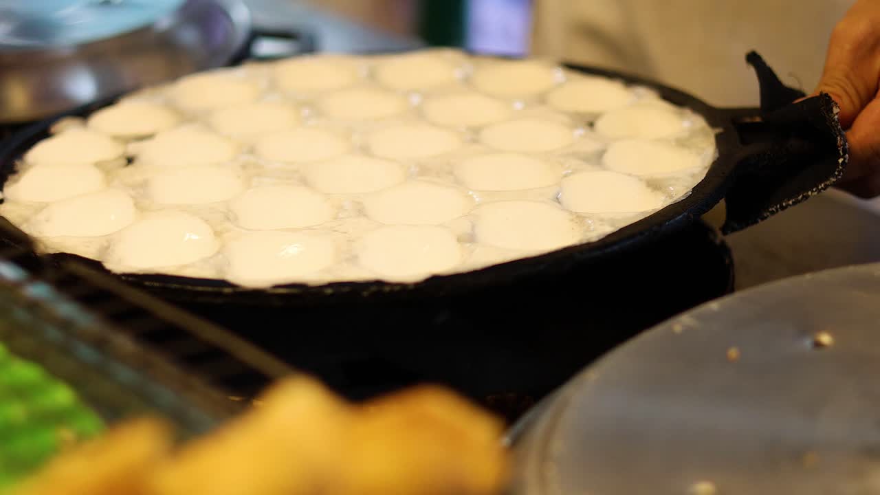 태국 전통 코코 팬케이크를 뜨거운 그릴에 조리하는 것