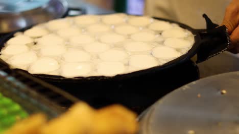 cocinando panqueques tradicionales de coco tailandeses en una parrilla caliente