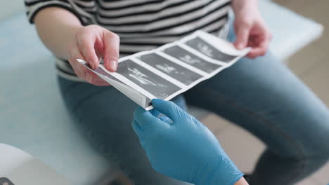 patient holds scan printout while the female doctor explains results, providing interpretation. both interact while discussing the medical images, highlighting the importance of clear communication