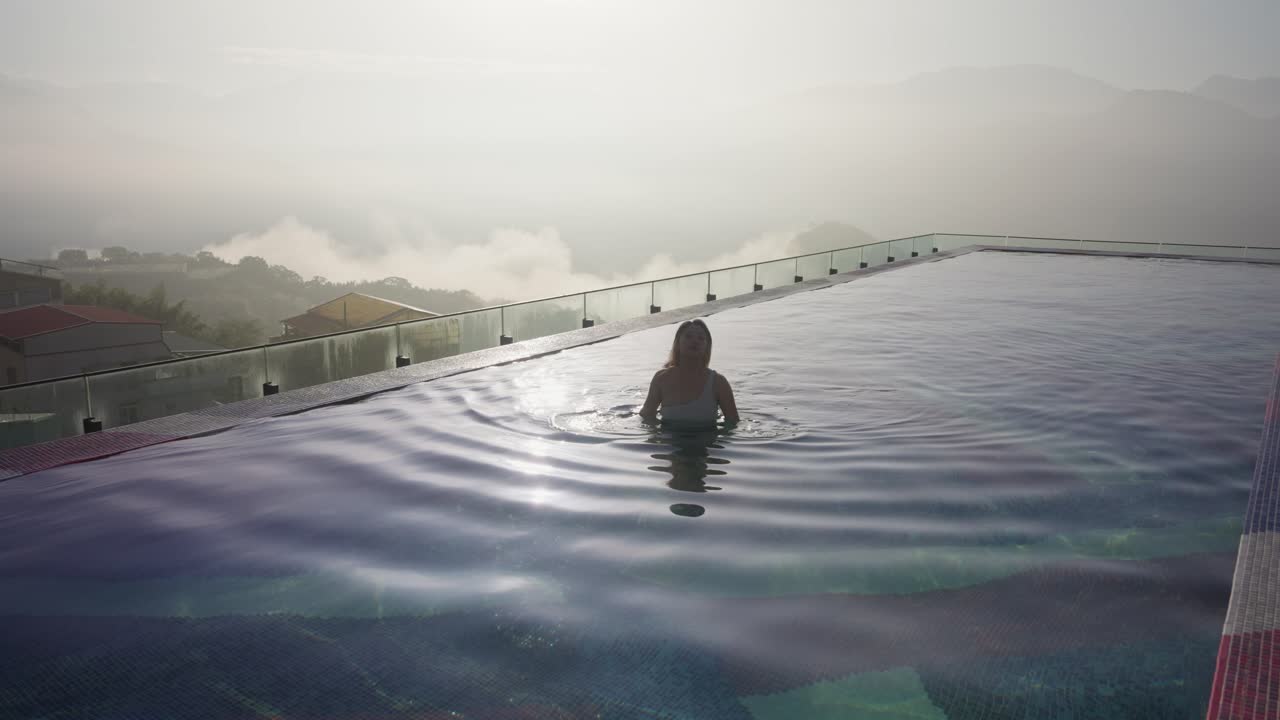 Asiatische Frau entspannt im Infinity-Pool eines Luxushotels in Taiwan