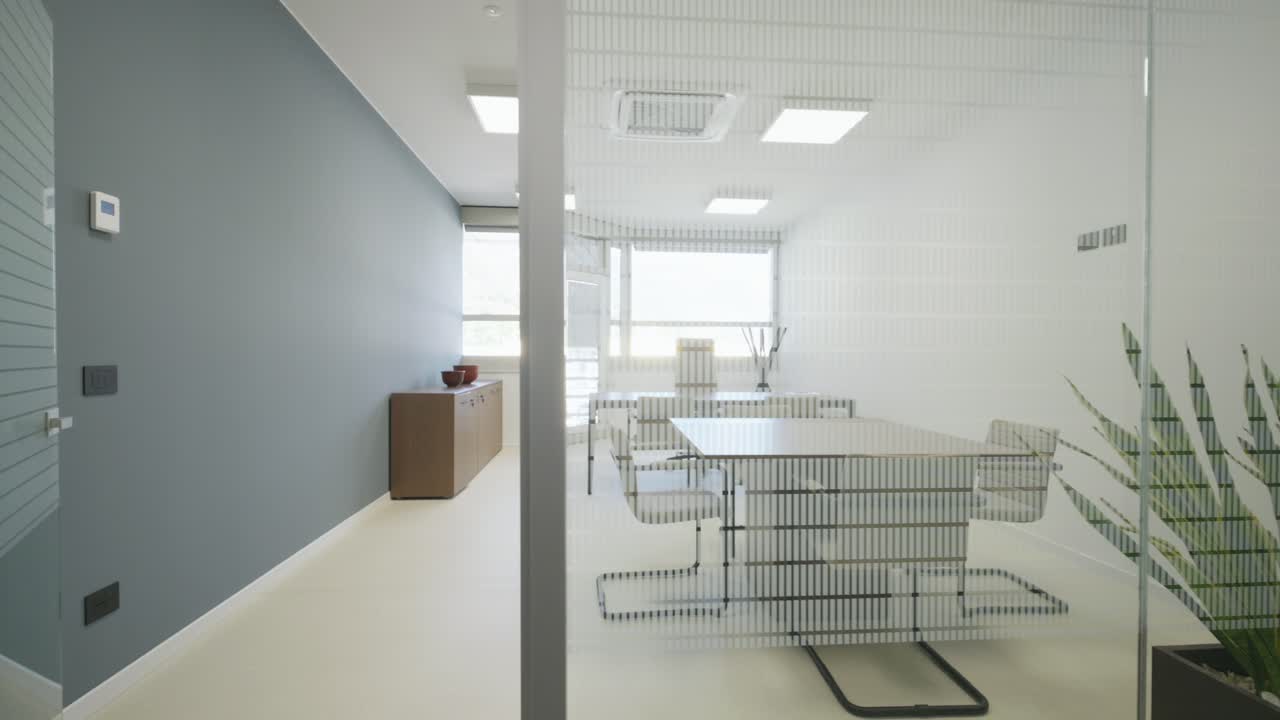 Luminoso y moderno interior de oficina con espacio de trabajo amueblado, mesa de reuniones y sillas. Diseño corporativo minimalista, luz natural y ambiente profesional y limpio, ideal para componente visual de negocios y consultoría.