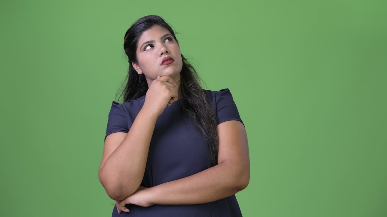 joven sobrepeso hermosa mujer de negocios india contra fondo verde