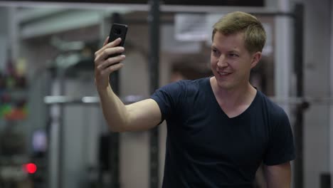 joven y guapo hombre escandinavo tomando selfies en el gimnasio
