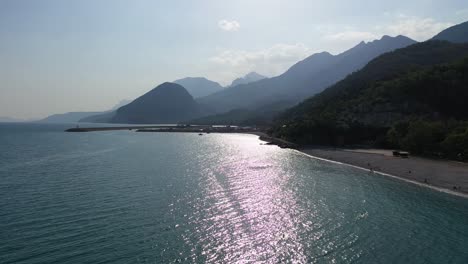 aerial view of beach and fishing port on turkish mediterranean sea coastline near antalya, drone shot