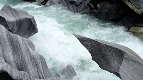 Marble-rock-with-water-running-in-the-river-of-Marmorslottet,-Norway